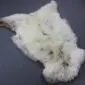 Natural cream and grey rare breed sheepskin rug with thick, textured wool and an irregular organic shape.