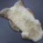Rare Breed Sheepskin Rug RBS133b Natural cream sheepskin rug with grey and brown markings and a thick, textured wool pile.
