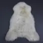 Natural cream rare breed sheepskin rug with grey and tan markings and long, textured wool.