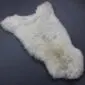 Natural cream rare breed sheepskin rug with long, textured wool and an organic shape.