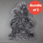 Two grey sheepskin rugs with long, textured wool piled together .