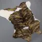 Natural calfskin rug with a brindle pattern of brown and black stripes on a white background.