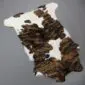 Natural calfskin rug with a white base and dark brown brindle patterned patches. detail view