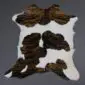 Natural calfskin rug with a white base and dark brown brindle patches in an irregular hide shape.