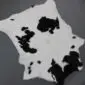 Natural shaped calfskin rug with black and white speckled markings.