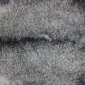 Close-up of a double Gotland sheepskin rug featuring natural grey curly wool with a central seam.