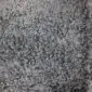 Close-up of a natural grey Gotland sheepskin rug featuring dense, curly wool fibres.