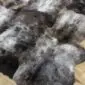 Rare-Breed Sheepskin Rug 6 Skin RBS6S-76 (7) Close-up of a thick, textured sheepskin rug with mottled grey, black, and white long-pile wool.