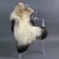 Rare breed sheepskin rug with long cream wool and dark brown markings laid flat.