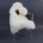Cream rare breed sheepskin rug with a small brown patch laid flat.