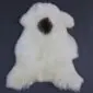 Natural white rare breed sheepskin rug with a single dark brown circular patch in the centre.