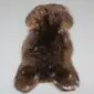 Large rare breed sheepskin rug with thick, textured wool in mottled dark brown and tan tones.