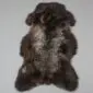 Large rare breed sheepskin rug with long, curly wool in mottled dark brown, grey and cream tones.