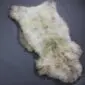 Large rare breed sheepskin rug with long, thick cream and grey wool in a natural pelt shape.