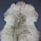 Large rare breed sheepskin rug with long, thick wool in natural cream and grey tones.