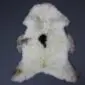 Large cream rare breed sheepskin rug with natural brown markings and a central dark spot on a grey background.