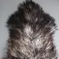 Natural grey Icelandic sheepskin rug with long, curly wool in variegated charcoal and silver tones.