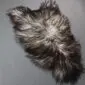 Natural grey Icelandic sheepskin rug with long, curly wool in variegated shades of charcoal, silver and cream.