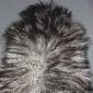 Natural grey Icelandic sheepskin rug with long, curly wool in variegated shades of charcoal and silver. detail view