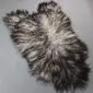 Natural grey Icelandic sheepskin rug with long, curly wool in variegated shades of charcoal and cream.