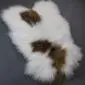 Icelandic Sheepskin Rug ISM388 (1) Long-haired white Icelandic sheepskin rug with large natural brown spots and an irregular organic shape.