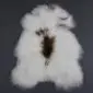 Long-pile white Icelandic sheepskin rug with a central dark brown and tan spot pattern.