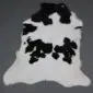 Natural calfskin rug with a white base and irregular black patches.