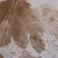 Close-up of a brown and white mottled cowhide rug showing natural hair texture and speckled patterns.
