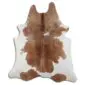 Irregularly shaped cowhide rug with tan brown patches on a white background.