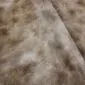 Close-up of a cowhide rug with mottled brown, tan, and cream natural hair patterns.