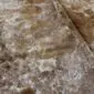 Close-up of a brown and white speckled cowhide rug showing natural hair texture and colour variations.