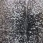 Cowhide Rug C01002 (2) Close-up of a speckled cowhide rug featuring a dense pattern of black, grey, and white natural hair.