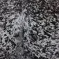 Cowhide Rug C01002 (3) Close-up of a speckled cowhide rug featuring a dense pattern of black and dark brown spots on a white background.