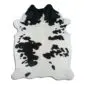 Natural shaped cowhide rug with a white base and irregular black speckled patterns.