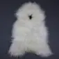 Off-white Icelandic sheepskin rug with long, shaggy wool and a natural hide shape .
