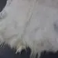 Natural white goatskin rug with long, textured hair and grey undertones.