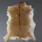 Natural goatskin rug with light brown fur, a dark dorsal stripe, and cream-coloured edges.