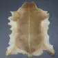 Natural goatskin rug with light brown fur, a darker dorsal stripe, and cream-coloured edges.