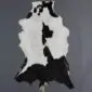 Natural goatskin rug with a white and black speckled pattern and irregular edges.