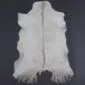 Natural white goatskin rug with a central tan stripe and long fringed edges on a dark background.