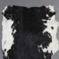 Natural goatskin rug with a black centre and white speckled edges.