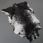 Natural goatskin rug with a speckled black and white pattern and irregular edges.