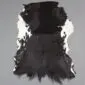 Natural goatskin rug with a large black centre and white speckled edges on a grey background.