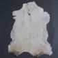 Natural goatskin rug with cream and light grey fur, featuring subtle tan markings and an irregular organic shape.