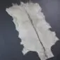 Goatskin Rug G1068 (4) Natural goatskin rug with cream and grey fur featuring a dark brown stripe down the centre.