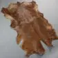 Natural goatskin rug with mottled brown and tan fur in an organic hide shape.