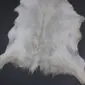 Natural white goatskin rug with grey and cream tones and an irregular organic shape.