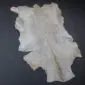 Goatskin Rug G1091 (4) Natural goatskin rug with cream and light grey fur, featuring an irregular organic shape on a dark background.