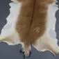 Natural goatskin rug with a light brown centre, cream edges, and a dark dorsal stripe.