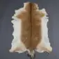 Natural goatskin rug with a light brown centre, dark dorsal stripe, and cream edges.